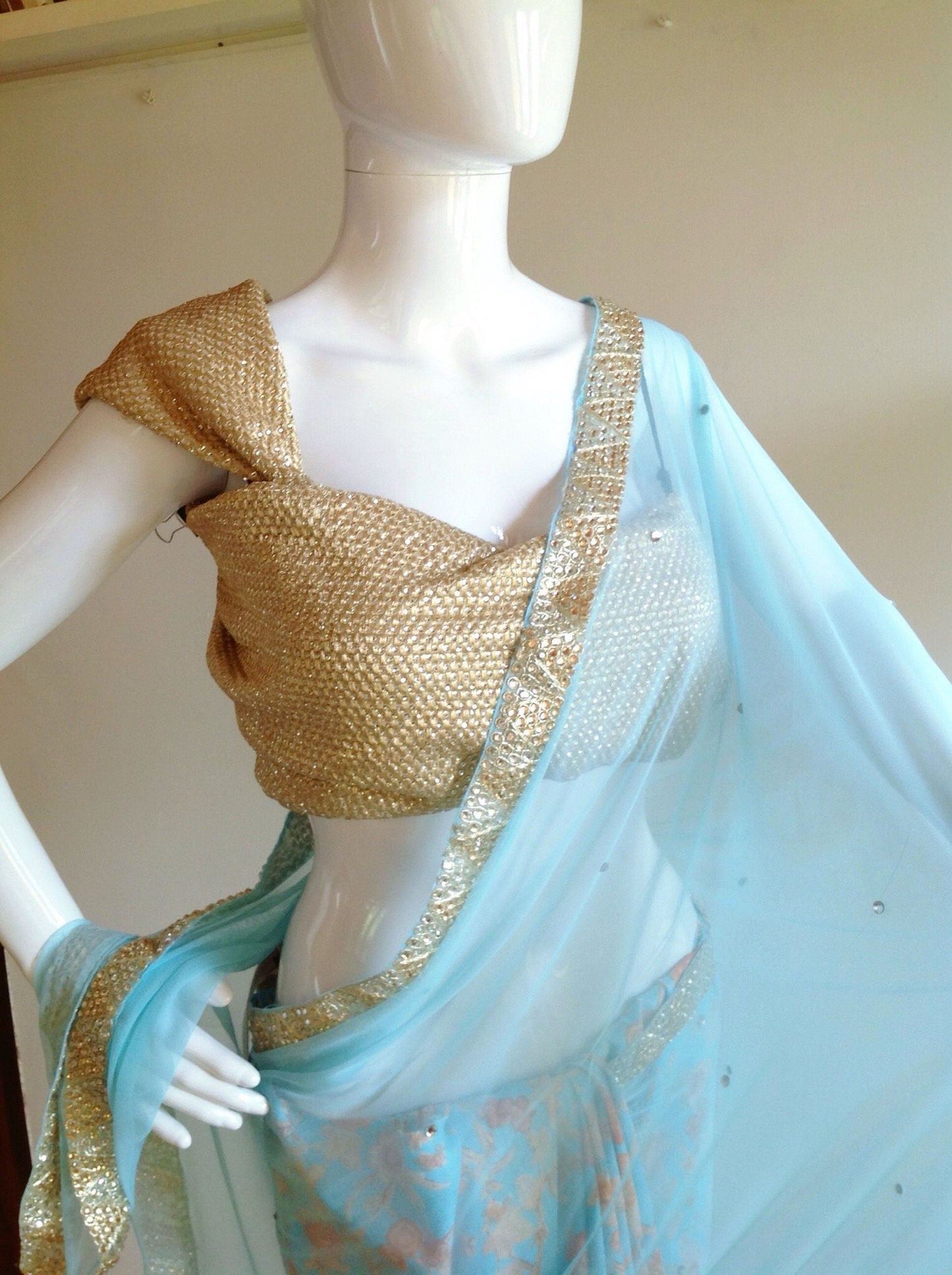 Soft blue net saree with stone work and gold sequin blouse