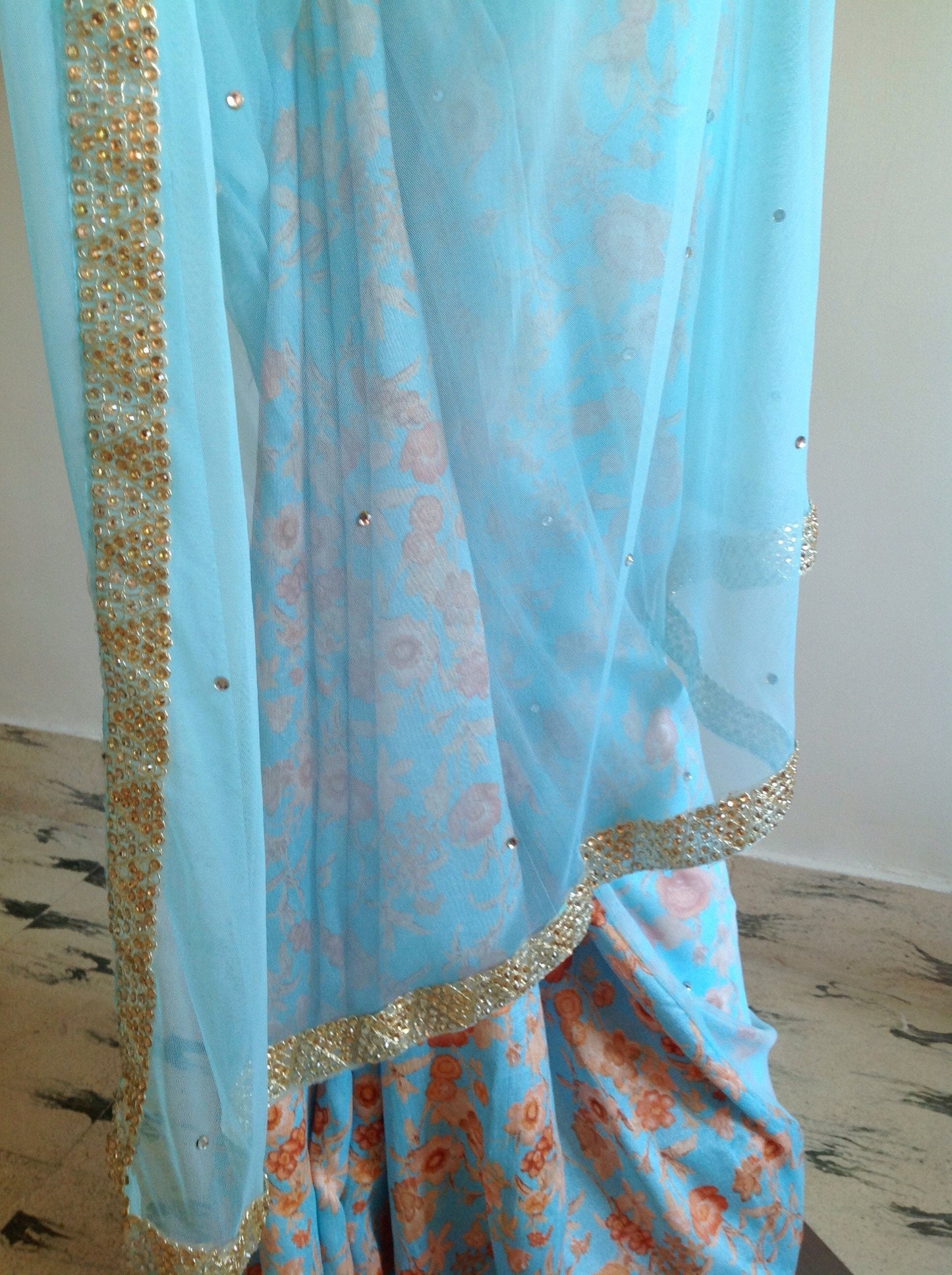 Soft blue net saree with stone work and gold sequin blouse