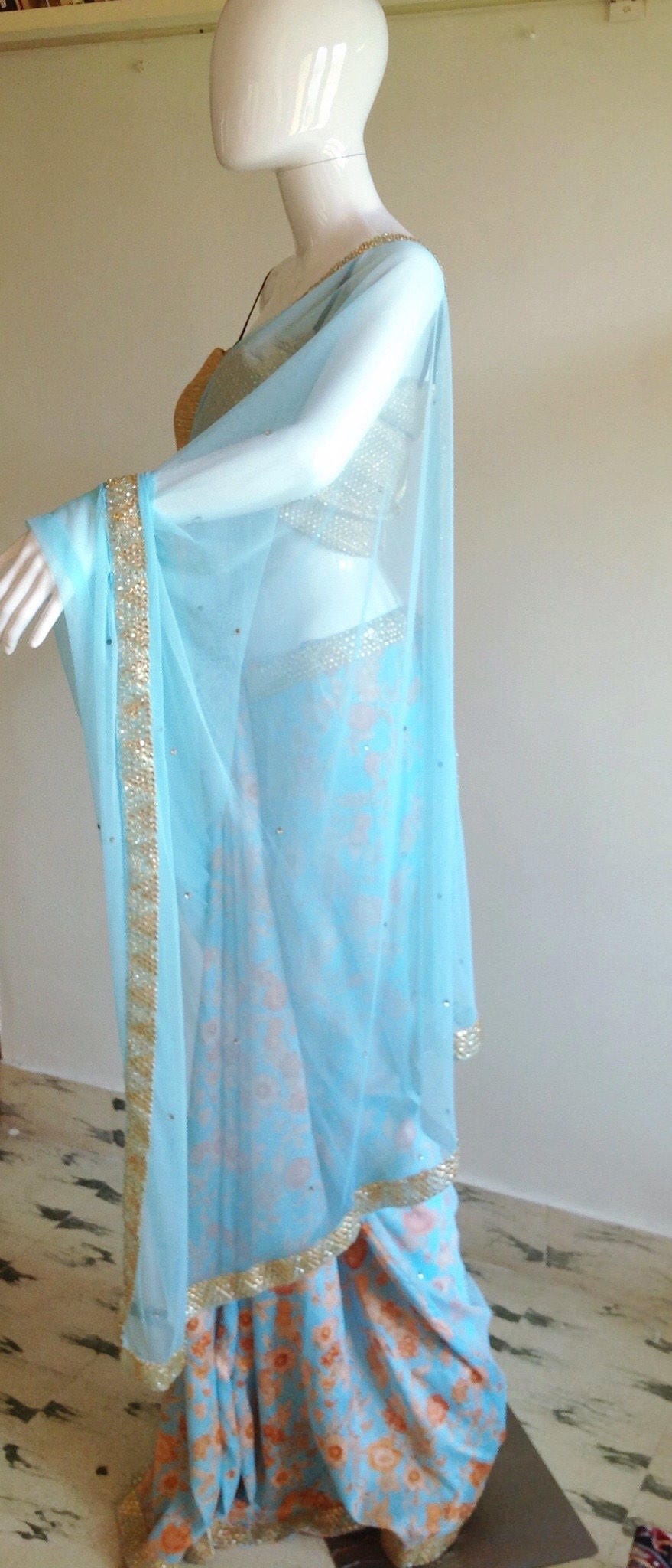 Soft blue net saree with stone work and gold sequin blouse