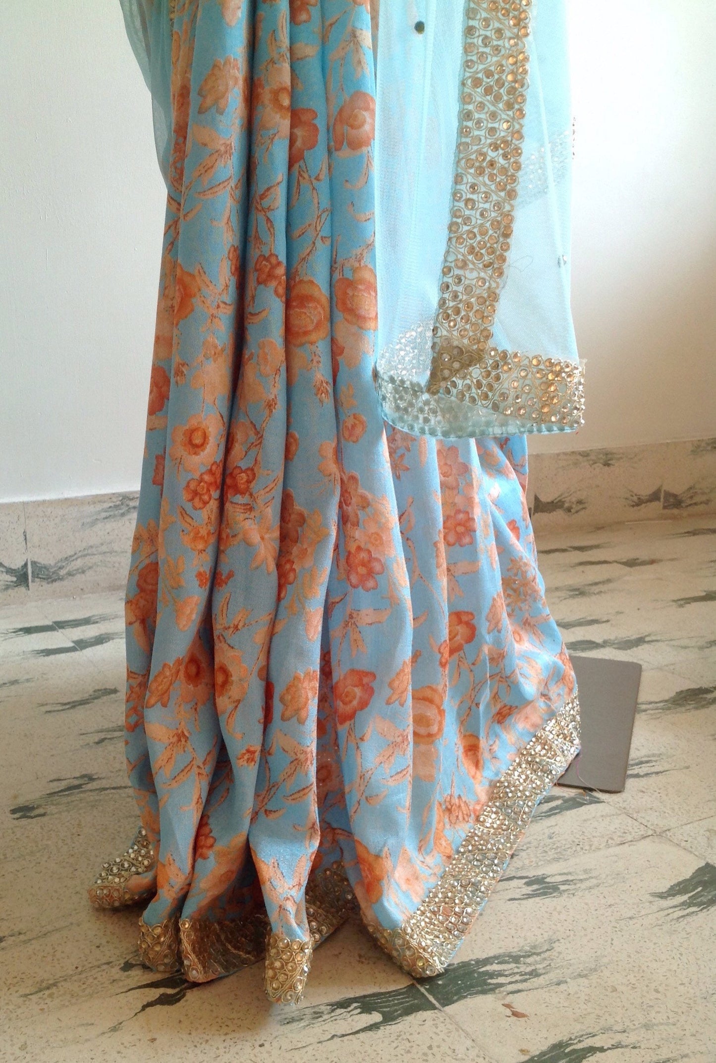 Soft blue net saree with stone work and gold sequin blouse