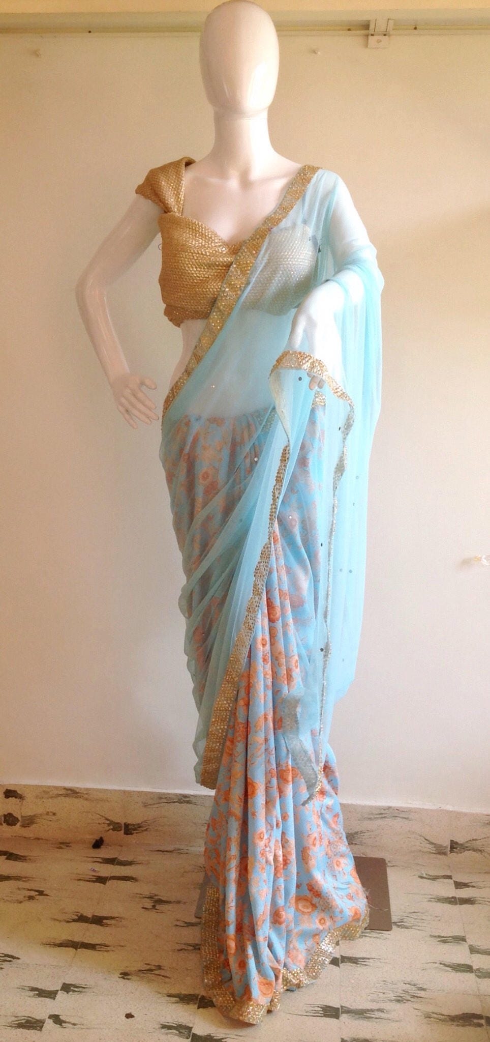 Soft blue net saree with stone work and gold sequin blouse
