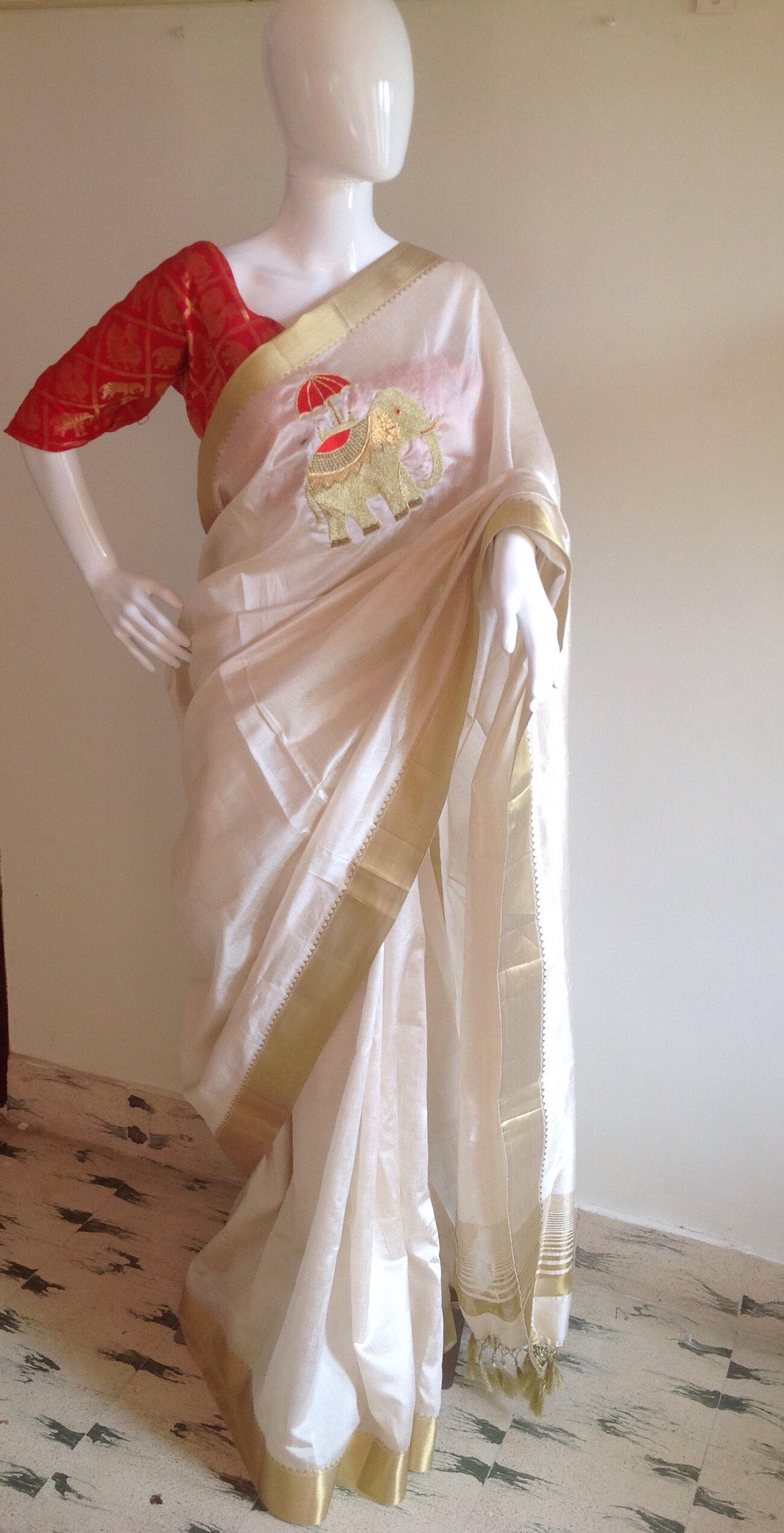 Offwhite semi silk saree with elephant hand embroidery and unstitched red pure silk brocade blouse with elephant weave