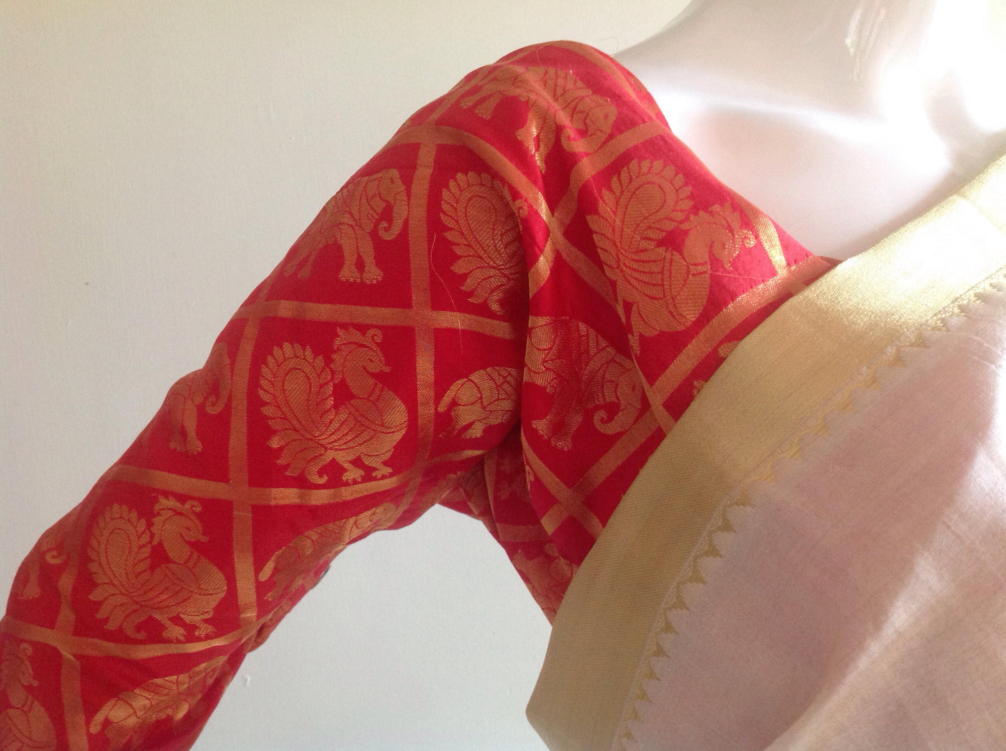 Offwhite semi silk saree with elephant hand embroidery and unstitched red pure silk brocade blouse with elephant weave