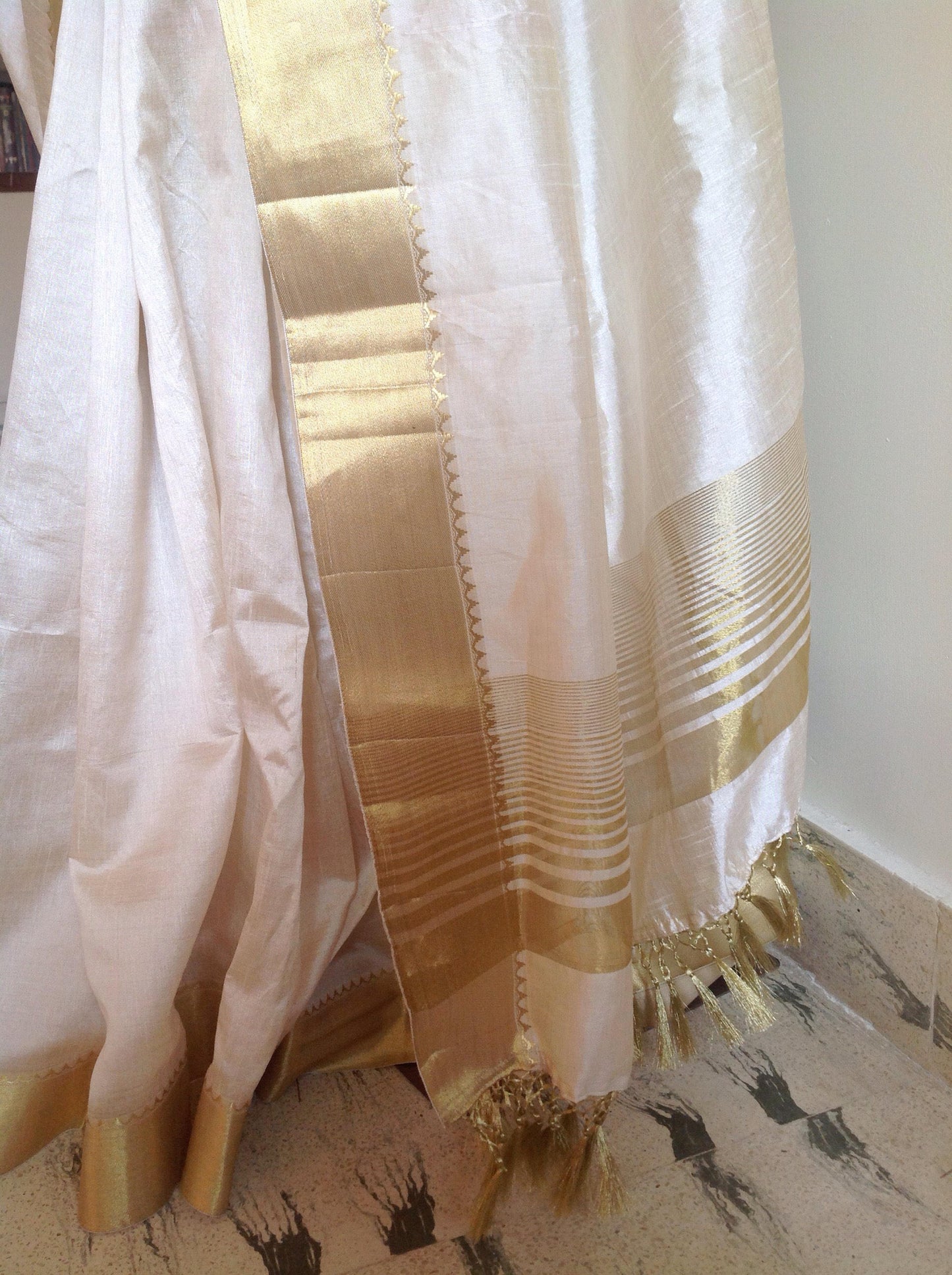 Offwhite semi silk saree with elephant hand embroidery and unstitched red pure silk brocade blouse with elephant weave