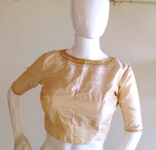 Ivory pure raw silk jwellery neck blouse with embroidery on the sleeves as well.