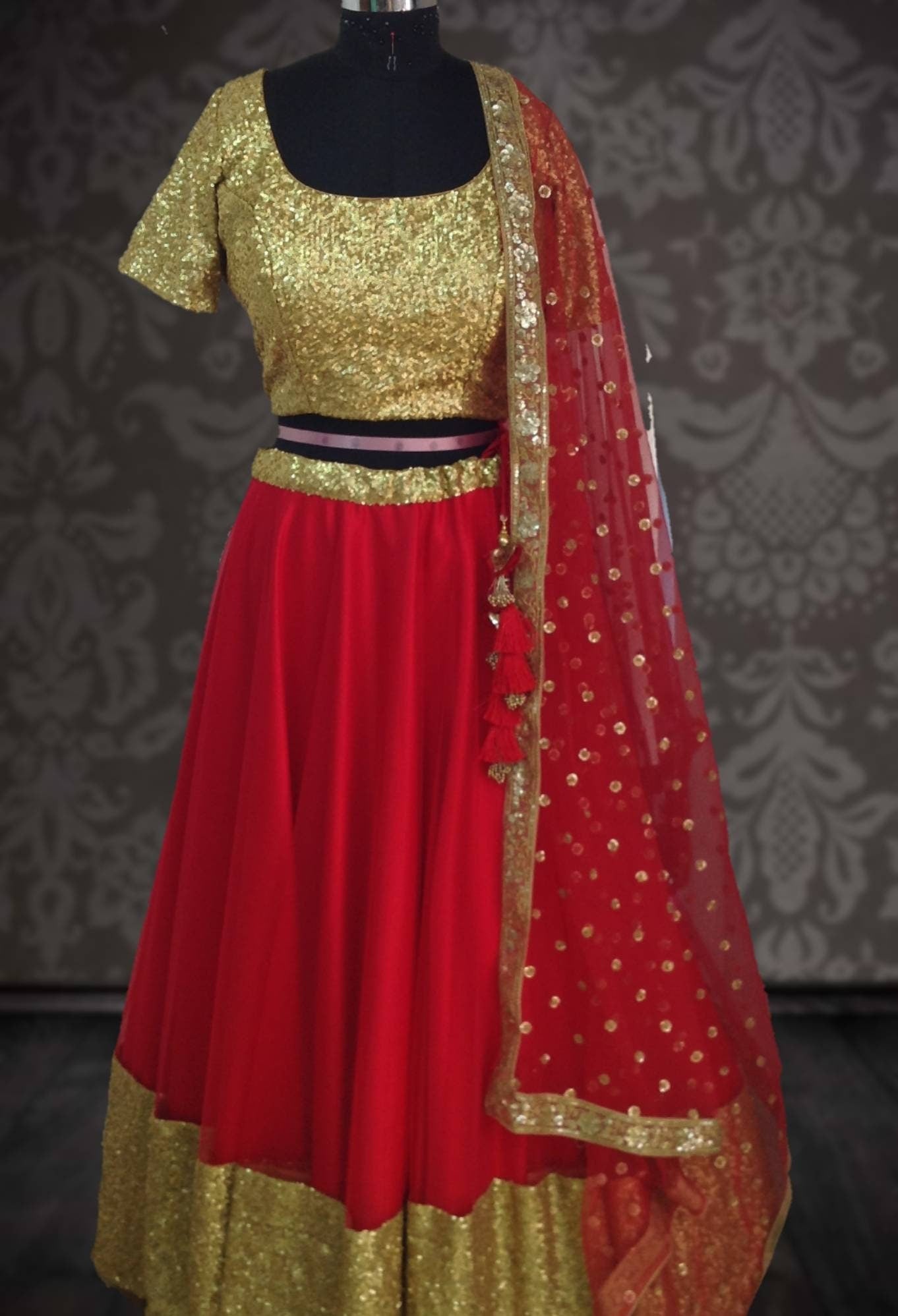 Bright red net lehenga with gold sequin blouse and sequin net dupatta